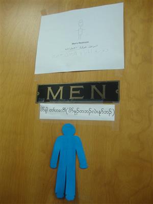Men's restroom door with signs in numerous languages